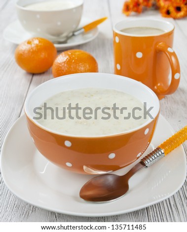 Oatmeal porridge in bowl on wooden table