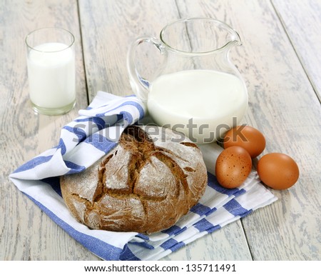 Eggs, milk and bread on a wooden table