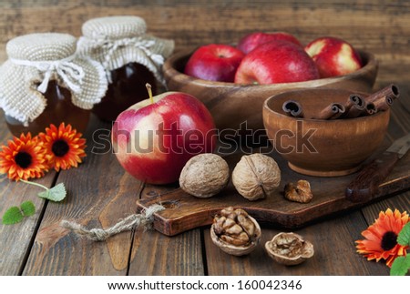 Apples, honey, cinnamon and walnuts on a wooden table