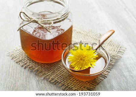 Dandelion jam in a jar on the wooden table