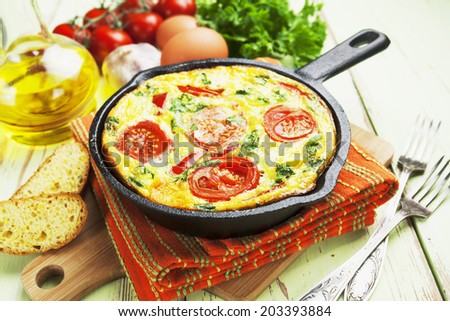 Omelet with vegetables and cheese. Frittata in a frying pan