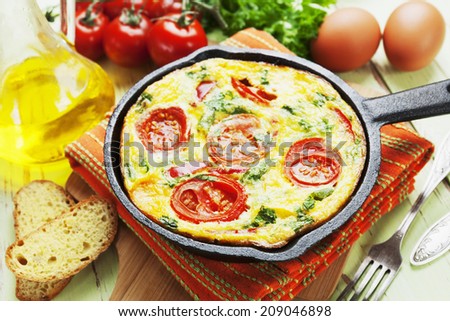 Omelet with vegetables and cheese. Frittata in a frying pan