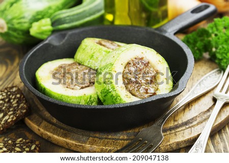 Zucchini with meat in the frying pan on the table