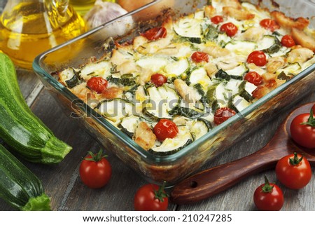 Baked zucchini with chicken, cherry tomatoes and herbs in a glass pot
