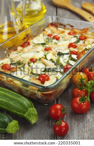 Baked zucchini with chicken, cherry tomatoes and herbs in a glass pot