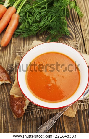 Carrot soup in blue bowl on the table