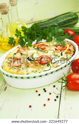 Baked zucchini with chicken, cherry tomatoes and herbs in a ceramic pot