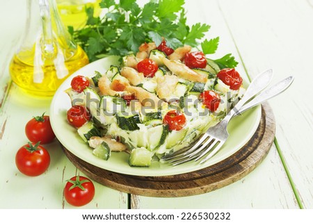 Baked zucchini with chicken, cherry tomatoes and herbs on a ceramic plate