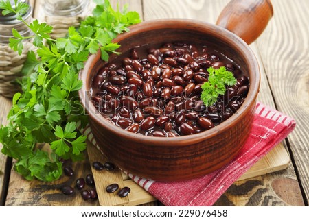 Bean stew in a ceramic pot on a wooden table