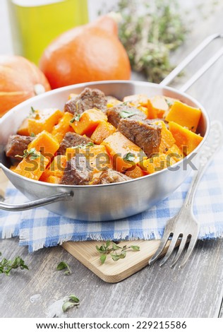 Pumpkin, baked with beef in the pot on the table