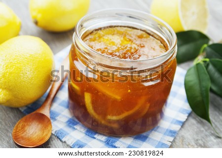 Lemon jam in the glass jar on the wooden table