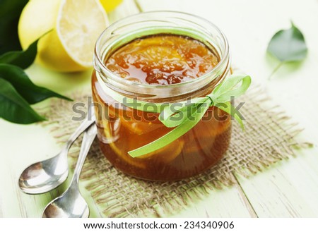 Lemon jam in the glass jar on the wooden table