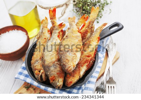 Fried fish in a frying pan on the table