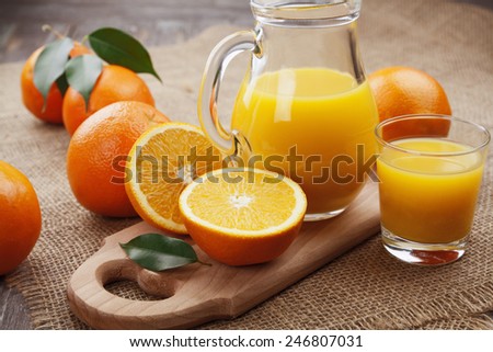 Orange juice  in the glass jug on the wooden table