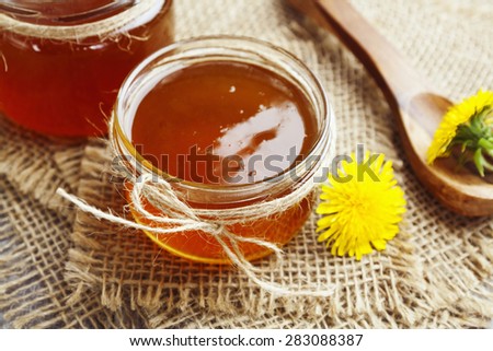 Jelly of dandelions in a glass jar on the table