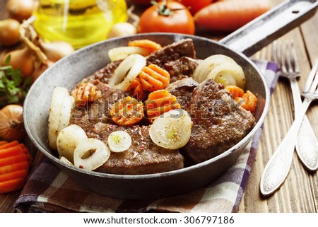 Liver fried with carrot and onion in a frying pan