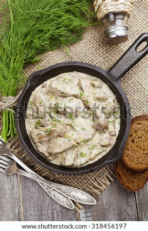 Liver stewed in sour cream in a frying pan
