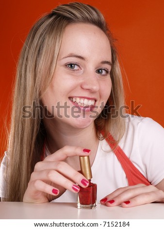Smiling blond girl applying nail polish