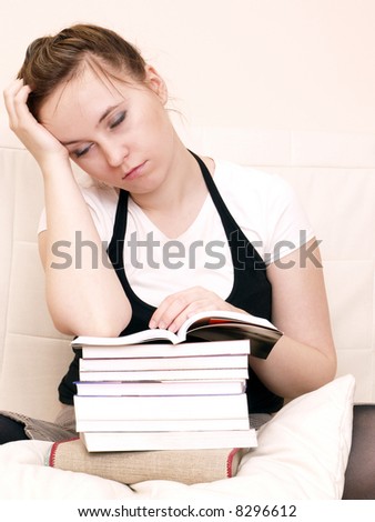 Young woman takes a break and sleeps on the couch with books