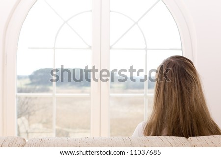 Young woman sitting on the sofa in front of window/ Window on the world / freedom / new time