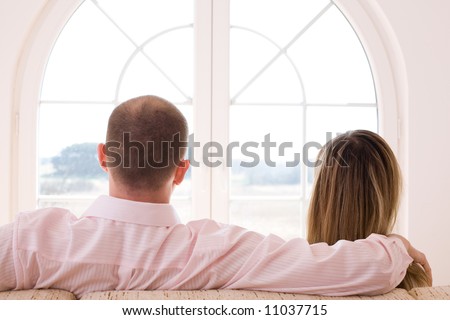 Couple sitting on the sofa in front of window/ Window on the world / freedom / new time