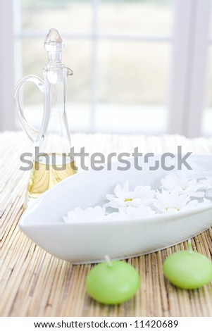 Bottle of essential oil, candles and fresh flowers / in the beauty salon