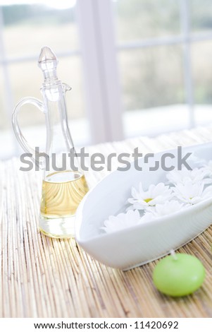 Bottle of essential oil, candle and fresh flowers / in the beauty salon