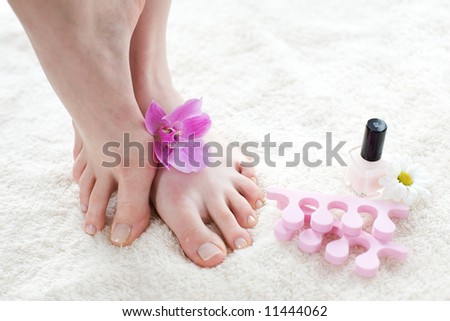 Beautiful female feet with pink orchid / pedicure