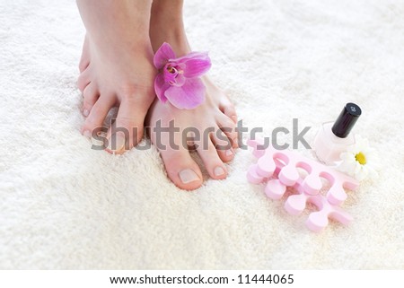 Beautiful female feet with pink orchid / pedicure