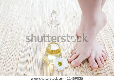 Spa and wellness scene - Foot care - Feet and oil on the bamboo mat