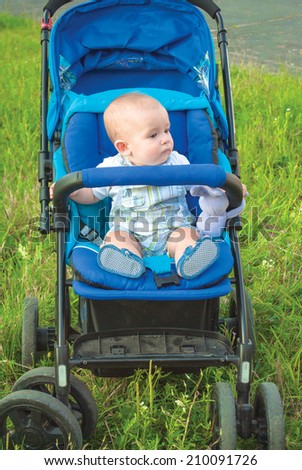 9 month old baby on blue baby carriage
