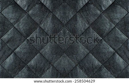 Black quilted leather fabric close up, abstract background
