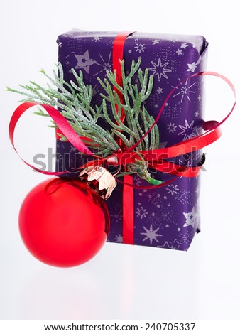 New Year\'s gift, the gift box packed into design paper it is wound by a red tape and the enclosed branch of a fir-tree and a Christmas ball.