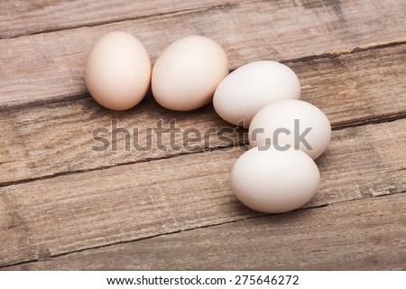 The eggs, the top view which are laid out by a half moon on a wooden table from old boards, nobody.