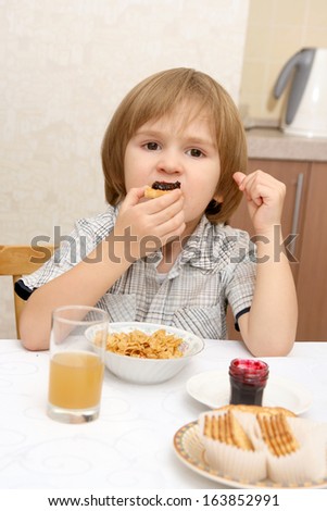 A boy eat cracker with jam