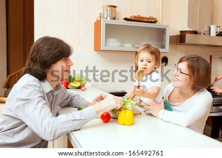 happy family couple with the baby at the kitchen table