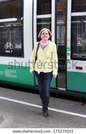 The smiling woman leaves the train