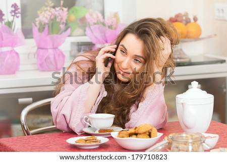 The attractive girl with cellphone on breakfast