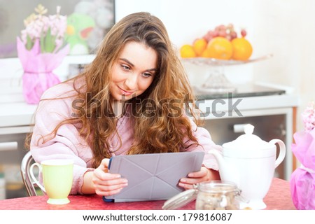 The young girl reads news on tablet PC