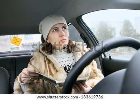 a young woman-driver focuses on the map