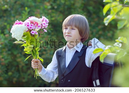 a boy with a bouquet goes to school on the first of September