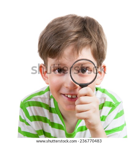 Smiling boy looking through a magnifying glass