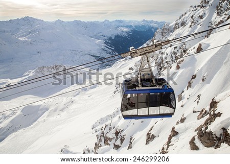 ST. ANTON, AUSTRIA - JAN 06, 2015: The Valluga\'s cable car cabin with tourists against snowy cliffs