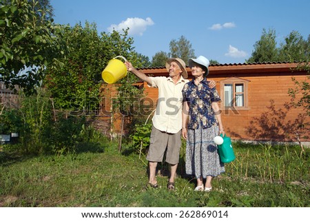 Happy elderly gardeners with a pail and watering can