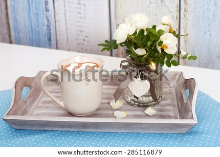 The tray with hot cocoa and white flowers of hedge rose