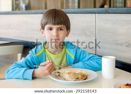 The six years boy eats chicken with mashed potatoes