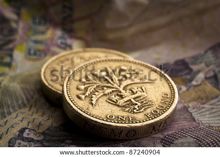 Two pound coins on crumpled five pound note.