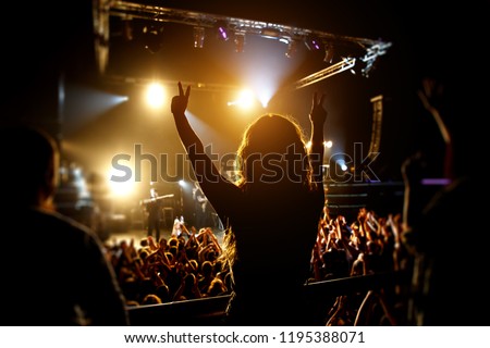Silhouette of Girl enjoying the music show, stage light