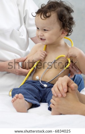 Cheerful child at the doctor.Playing with stethoscope.