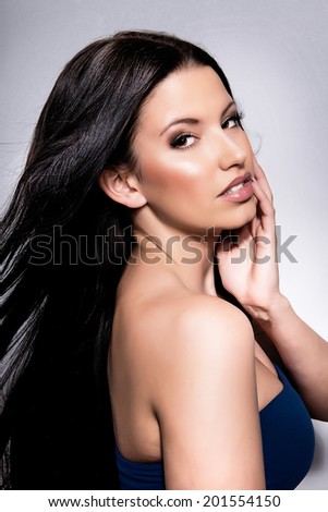 Beautiful woman with long straight hair. Fashion model posing at studio.